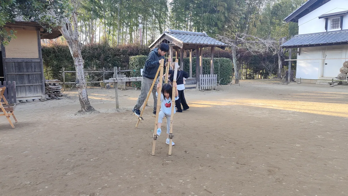 房総のむらの広場で木のやぐらによじ登って遊ぶ子ども
